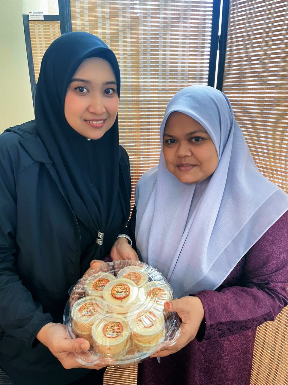 Dua pelanggan memegang tray puding bersama